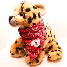 Load image into Gallery viewer, Classic red bandana print over-the-collar bandana. Has classic bandana pattern with black and white dogs and white bones. Displayed on a cute stuffed tiger toy..