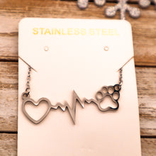 Load image into Gallery viewer, Silver necklace with open heart, heartbeat rhythm, and open pet paw. Displayed on necklace card.