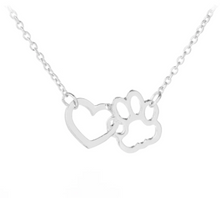 Load image into Gallery viewer, Silver tone necklace with open heart charms intertwined with open pet paw charms. Displayed on white background.
