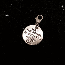 Load image into Gallery viewer, A picture of a silver round charm with the outline of Yoday and the words "May the Force Be With You." Charm has a lobster clasp and is displayed on a black night sky background.