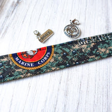Load image into Gallery viewer, Close up of the Marine Digital pattern Wristlet keychain on white wood with a Brave charm and Marine Seal charm. 
